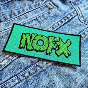 May include: Green embroidered patch with the word "NOFX" in a stylized font on a teal background.