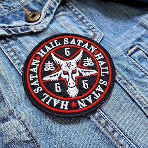 May include: A black and red embroidered patch with a pentagram and a goat's head in the center. The text around the pentagram reads "Hail Satan Hail Satan".