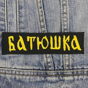 May include: Black patch with yellow embroidered text that reads "Батьошка".