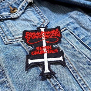 May include: A black and red embroidered patch with the text "Possessed Seven Churches" in a gothic font. The patch features a white cross design and is sewn onto a denim jacket.