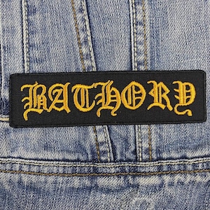 May include: Black patch with the word "RATHORY" in yellow embroidered letters.