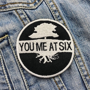 Puede incluir: Parche bordado en blanco y negro con un árbol y el texto "You Me At Six".