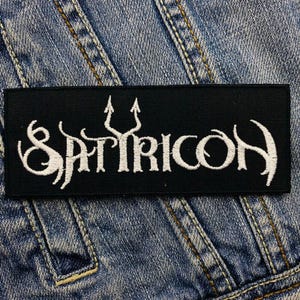 May include: Black embroidered patch with the white text "SATRICON" and a trident symbol.
