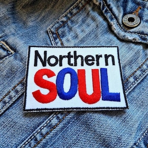 Peut inclure: Patch blanc avec le texte noir "Northern Soul" et des lettres brodées rouges et bleues.