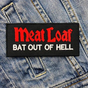 Może przedstawiać: Czarno-biała naszywka haftowana z czerwonym tekstem. Naszywka zawiera napis "Meat Loaf Bat Out Of Hell".