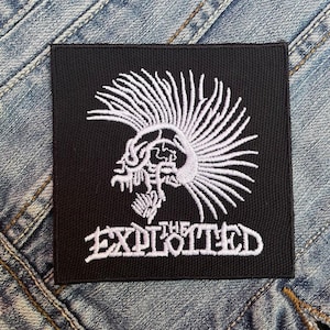 Può includere: Toppa ricamata in bianco e nero con un design di teschio punk rock e mohawk. Il testo "The Exploited" è sotto il teschio.