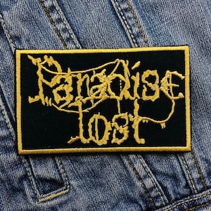 May include: Black embroidered patch with gold stitching. The patch features the text "Paradise Lost" in a stylised font.