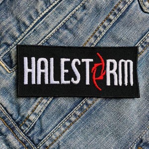 Puede incluir: Parche negro con el texto bordado en blanco "HALESTORM" y un logotipo estilizado rojo.
