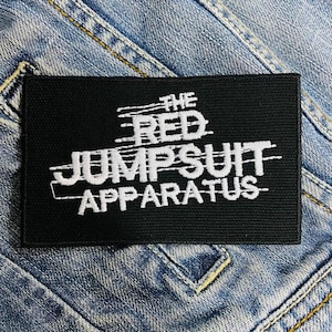Pode incluir: Remendo preto com texto bordado branco que diz "The Red Jumpsuit Apparatus".