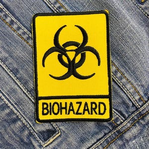 May include: Yellow biohazard warning sign with a black biohazard symbol and the word "BIOHAZARD" in black letters.