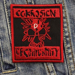 Könnte beinhalten: Ein quadratischer schwarzer Aufnäher mit rotem gesticktem Text und einem Totenkopf-Design. Der Text lautet "CORROSION" über einem Totenkopf mit einem "D" in der Mitte und "OF CONFORMITY" darunter. Der Aufnäher befindet sich auf einer Jeansjacke.