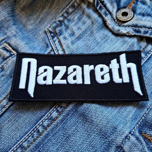 May include: Black and white embroidered patch with the word "Nazareth" in white lettering on a black background.