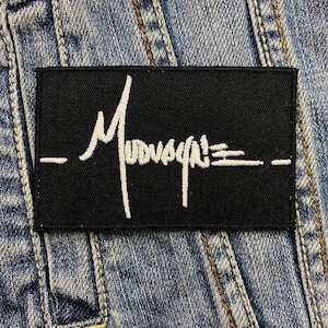 May include: Black patch with white embroidered text that reads "_Mossy Oak_"