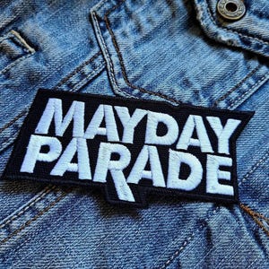 May include: Black and white embroidered patch with the text "Mayday Parade" in white lettering on a black background.