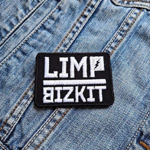 Puede incluir: Parche bordado en blanco y negro con el texto "LIMP BIZKIT" y un símbolo de rayo.
