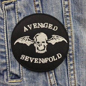 May include: Black and white embroidered patch featuring the band name "Avenged Sevenfold" and a skull with wings.