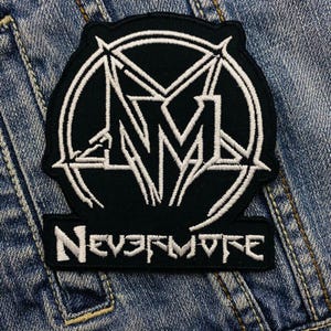 May include: Black and white embroidered patch with a stylized logo and the text "NEVERMORE".