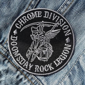 May include: Black and white embroidered patch with the text "Chrome Division Doomsday Rock Legion" in a circle. The patch features a skeletal figure holding a scythe.