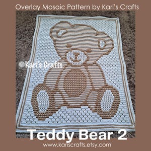 Op de afbeelding: Een handgemaakte gehaakte deken met een teddybeerontwerp. De deken is voornamelijk wit met een bruin teddybeerontwerp in het midden. De tekst "Overlay Mosaic Pattern by Kari's Crafts" en "Teddy Bear 2" zijn zichtbaar.