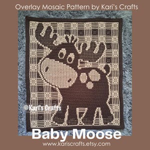 Puede incluir: Una manta de ganchillo mosaico marrón y beige con un diseño de alce bebé. La manta tiene un borde a cuadros y el texto "Baby Moose" en la parte inferior. También es visible el nombre de la tienda Etsy "Kari's Crafts".