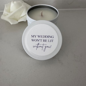 May include: White candle in a tin with a white label that says "My wedding won't be lit without you!"