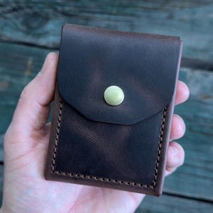 May include: A rustic wooden sign with the text "Welcome to our home" in white lettering. The sign features a distressed finish and a simple, inviting design, perfect for entryway decor.