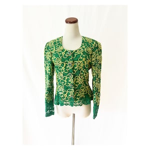 May include: A green lace jacket with yellow floral embroidery and button closures.