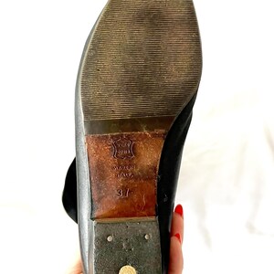 May include: Black leather ankle boots with a brown leather sole. The sole is marked "Made in Italy" and "37".