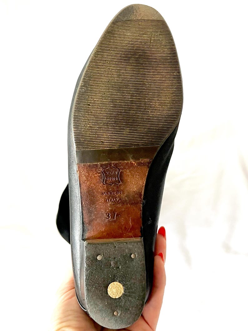 May include: Black leather ankle boots with a brown leather sole. The sole is marked "Made in Italy" and "37".