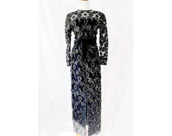 May include: A long black gown with a silver floral pattern and a black satin sash.