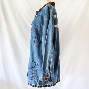 May include: A vintage denim jacket with a brown corduroy collar and trim. The jacket features two front pockets, button closures, and a decorative pattern on the back. The hemline and cuffs have a brown and white checkered design.