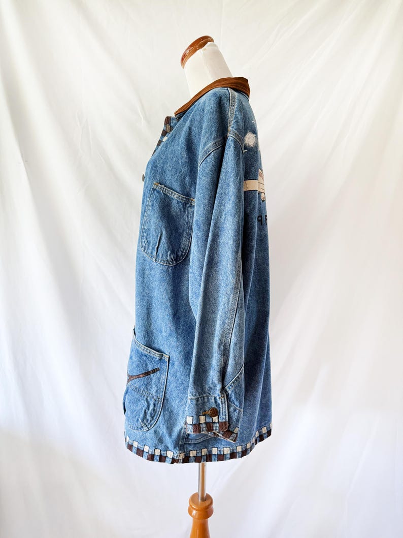 May include: A vintage denim jacket with a brown corduroy collar and trim. The jacket features two front pockets, button closures, and a decorative pattern on the back. The hemline and cuffs have a brown and white checkered design.
