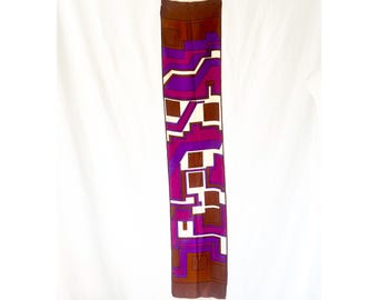 May include: A long, brown silk scarf with a geometric pattern in shades of purple, white, and brown.