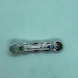 May include: Silver hair clip with five round, clear rhinestones.