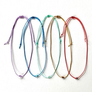 Puede incluir: Seis pulseras de cuerda de colores con pequeñas cuentas. Las pulseras son en tonos de morado, azul, verde, turquesa, dorado y rojo.