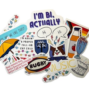 May include: A collection of colorful stickers with various designs and text. The stickers include phrases like "I'm Bi, Actually," "Why are we like this?" and "Rugby." Other designs include a dog, a milkshake, and a drum.