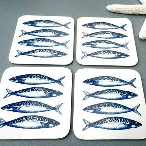 May include: Set of four square coasters featuring a blue and white illustration of mackerel fish. The coasters are made of a white material with a smooth surface.