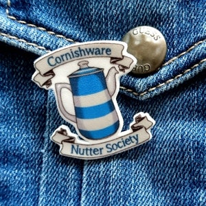 May include: A blue and white striped ceramic teapot with a white ribbon that says "Cornishware" and another white ribbon that says "Nutter Society".