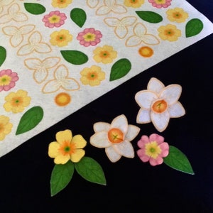 May include: A sheet of paper with various flower stickers, including white, yellow, pink, and orange flowers. There are also green leaves. The stickers are arranged in a pattern. Below the sheet of paper are four individual flower stickers, including a white daffodil, a pink flower, and two yellow flowers.