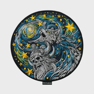 May include: A circular embroidered patch featuring a howling wolf and a horned skull against a swirling blue and yellow starry night sky. The design includes yellow stars and a small black tag at the bottom with the text WOLF CLAW.US in white.