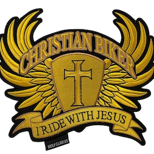 Könnte beinhalten: Ein gold gestickter Patch mit einem christlichen Biker-Motiv. Er zeigt ein Kreuz in einem Schild mit Flügeln und einem Banner mit der Aufschrift "Ich fahre mit Jesus".