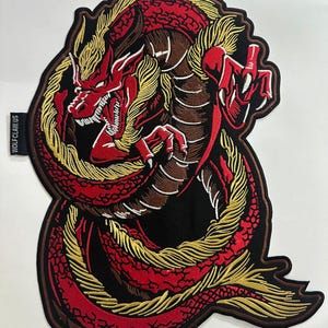 Peut inclure: Un patch brodé de dragon rouge et or avec le texte "WOLFCLAW US" sur le côté.