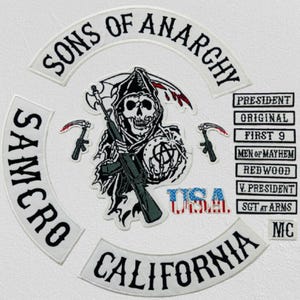 May include: A collection of embroidered patches with the text "SONS OF ANARCHY", "SAMCRO", and "CALIFORNIA". The central patch shows a grim reaper figure with a rifle and scythe. Other patches include phrases like "PRESIDENT".