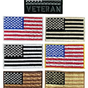 May include: Set of ten embroidered American flag patches. The patches are in various color combinations, including black, white, gray, red, blue, and tan. The patches feature the words "Veteran" in black.