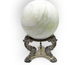 May include: A white marble sphere with green swirls sits on a silver stand with ornate details.