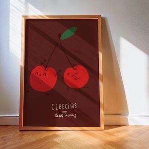 Puede incluir: Una impresión artística enmarcada con dos cerezas de dibujos animados con caras sonrientes y brazos, conectadas por un tallo y una hoja verde. Las cerezas son rojas sobre un fondo rojo oscuro. El texto "Cerecitas to take away" está escrito debajo.