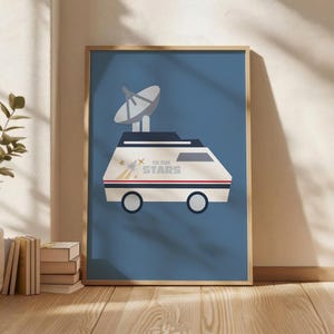 Puede incluir: Impresión artística enmarcada que representa un vehículo blanco con una antena parabólica sobre un fondo azul. El vehículo tiene el texto "TO THE STARS" y un diseño de estrellas y rayas. El marco es de color marrón claro.