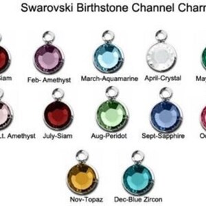 May include: A set of 12 Swarovski birthstone channel charms, each featuring a different colored gemstone. The charms are arranged in a grid, with the month and birthstone name listed below each charm. The charms are perfect for adding a personal touch to jewelry.