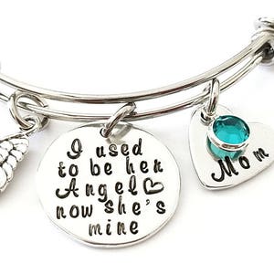 May include: Silver bangle bracelet with a charm that reads "I used to be her Angel now she's mine" and a heart charm with a turquoise stone that reads "Mom".