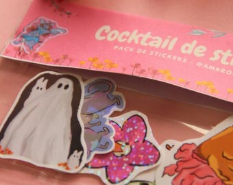 May include: A pack of stickers with various designs, including a ghost, a flower, and other colorful illustrations. The packaging is pink and reads "Cocktail de stickers". Orange flowers are in the background.